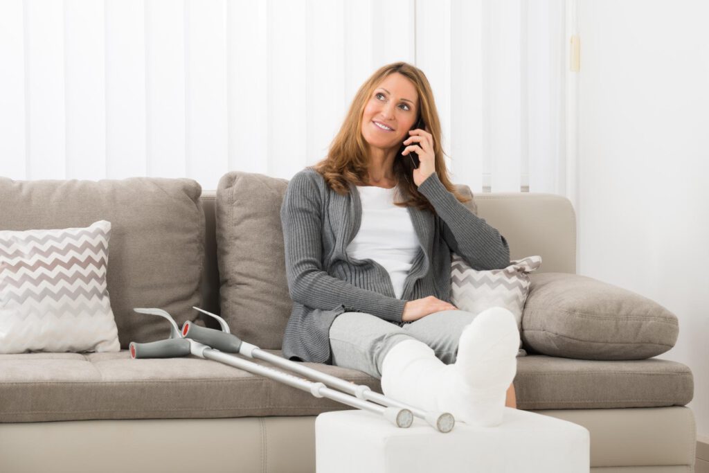 Frau mit gebrochenem Bein telefoniert